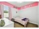Charming bedroom with pink accents, light-filled with soft decor creating a cozy retreat at 8228 Sunlit Horizon Ln, Land O Lakes, FL 34637