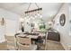 Bright dining room with modern chandelier, neutral decor and views to living room and backyard at 8228 Sunlit Horizon Ln, Land O Lakes, FL 34637