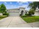 Single story home with neutral paint, 2 car garage, and lush landscaping at 8228 Sunlit Horizon Ln, Land O Lakes, FL 34637