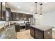 Modern kitchen with dark cabinets, granite countertops, and stainless steel appliances at 8228 Sunlit Horizon Ln, Land O Lakes, FL 34637