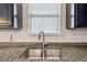 Close up of kitchen sink with granite countertops, stainless steel basin and fixtures, and window with blinds at 8228 Sunlit Horizon Ln, Land O Lakes, FL 34637