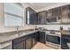 Close-up of kitchen area featuring granite countertops, stainless steel appliances, and sleek dark cabinetry at 8228 Sunlit Horizon Ln, Land O Lakes, FL 34637