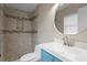 Stylish bathroom with a modern vanity, round mirror, and tiled shower with built-in niche at 8407 Granite Pl, Tampa, FL 33615