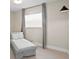 Minimalist bedroom featuring a chaise lounge, neutral tones, and ample natural light, creating a relaxing space at 8407 Granite Pl, Tampa, FL 33615