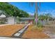 Charming single-story home with a stepping stone walkway, colorful landscaping, and vibrant red front doors at 8407 Granite Pl, Tampa, FL 33615
