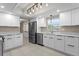 A modern kitchen featuring stainless steel appliances, white cabinetry, and quartz countertops at 8407 Granite Pl, Tampa, FL 33615