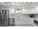 A modern kitchen featuring stainless steel appliances and white cabinetry at 8407 Granite Pl, Tampa, FL 33615