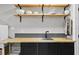 Kitchenette area showing floating wooden shelves, sink, black cabinets, and butcher block counters at 8407 Granite Pl, Tampa, FL 33615