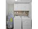 Well-equipped laundry room featuring modern washer, dryer, and water heater at 8407 Granite Pl, Tampa, FL 33615