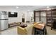 Living area with a couch, refrigerator, shelves with a ladder, TV, and access to the bathroom at 8407 Granite Pl, Tampa, FL 33615