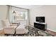 Relaxing living room featuring a comfortable armchair, patterned rug, and natural light creating a serene atmosphere at 8407 Granite Pl, Tampa, FL 33615