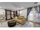 Cozy living room with a gold couch, ceiling fan, shelves with a ladder, and an area rug at 8407 Granite Pl, Tampa, FL 33615