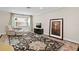 Comfortable living room with a patterned rug, a cozy armchair, and bright natural light from the window at 8407 Granite Pl, Tampa, FL 33615