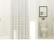 Bright bathroom features a tub with white tile surround and neutral shower curtain, plus modern toilet and decor at 8449 Sea Ray Run, Parrish, FL 34219