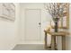 Bright hallway showcasing a console table with decor, artwork, and a welcoming door at 8449 Sea Ray Run, Parrish, FL 34219