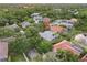 Aerial view of the property with a well-maintained roof, screened lanai, and lush landscaping; a peaceful pond nearby at 10232 Estuary Dr, Tampa, FL 33647