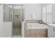 Bright bathroom featuring a tub, glass shower, and shuttered windows at 10232 Estuary Dr, Tampa, FL 33647
