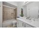 Bathroom featuring a shower-tub, vanity and white cabinets with gold hardware at 10232 Estuary Dr, Tampa, FL 33647