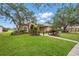 Beautifully landscaped front yard featuring mature trees, lush lawn and walkway leading to home at 10232 Estuary Dr, Tampa, FL 33647