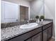 Bathroom with granite countertops, white sink, dark wood cabinets, and large mirror at 10669 Bridgegate Heights Loop, San Antonio, FL 33576