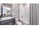 Bright bathroom features a shower-tub combo, granite countertop, and a gray vanity cabinet at 10669 Bridgegate Heights Loop, San Antonio, FL 33576