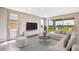 Sun-filled living room with modern furniture, neutral tones, large windows, and a view of the outdoors at 10669 Bridgegate Heights Loop, San Antonio, FL 33576
