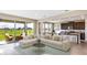 Bright open-concept living space with a comfortable sectional sofa, backyard view, and kitchen bar seating at 10669 Bridgegate Heights Loop, San Antonio, FL 33576
