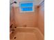 Pink bathroom featuring a tub, tile walls, and window at 11447 Park Blvd # 301, Seminole, FL 33772