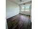 Bright bedroom featuring wood-look floors and a large window at 11447 Park Blvd # 301, Seminole, FL 33772