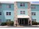 Three-story condo complex with light blue accents, neutral colors, and landscaping around the entrance at 11447 Park Blvd # 301, Seminole, FL 33772