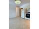 View of kitchen and a spacious living room with tile flooring and a modern light fixture at 11447 Park Blvd # 301, Seminole, FL 33772