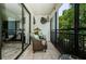 Balcony featuring patio furniture, decorative plant art and exterior wooded views at 1290 Pine Ridge E Cir # G1, Tarpon Springs, FL 34688