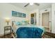 Bedroom featuring bed with floral bedding, ceiling fan, large window, pier themed art, and closet at 1290 Pine Ridge E Cir # G1, Tarpon Springs, FL 34688