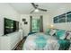 Bedroom with ceiling fan, floral bedding, large window, pier themed art, and a dresser at 1290 Pine Ridge E Cir # G1, Tarpon Springs, FL 34688