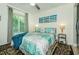 Comfortable bedroom with floral bedding, large window and decorative pier themed art at 1290 Pine Ridge E Cir # G1, Tarpon Springs, FL 34688
