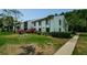 Charming two-story condo with lush landscaping and colorful flowers along the walkway at 1290 Pine Ridge E Cir # G1, Tarpon Springs, FL 34688