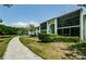 Exterior view of two-story condo buildings with screened patios and sidewalk surrounded by green space at 1290 Pine Ridge E Cir # G1, Tarpon Springs, FL 34688