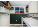 Bright laundry room with a full washer and dryer, shelves, and towel rack at 1290 Pine Ridge E Cir # G1, Tarpon Springs, FL 34688