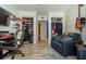Living room featuring comfortable seating, work desk, TV, and open closets at 1290 Pine Ridge E Cir # G1, Tarpon Springs, FL 34688