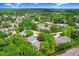 Serene aerial view of the condo nestled amongst lush greenery and a tranquil lake, highlighting community charm at 134 Sycamore Ln # F, Oldsmar, FL 34677