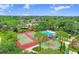Aerial view of community amenities including tennis and basketball courts, and a sparkling pool at 134 Sycamore Ln # F, Oldsmar, FL 34677