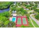 Aerial image highlights the variety of amenities, featuring tennis and basketball courts, and a community pool near a lake at 134 Sycamore Ln # F, Oldsmar, FL 34677