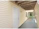 Condo entryway featuring a white door and yellow siding at 134 Sycamore Ln # F, Oldsmar, FL 34677
