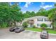 Two-story condo building with yellow siding, blue shutters, and a parking area with parked cars at 134 Sycamore Ln # F, Oldsmar, FL 34677