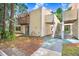 Two-story condo with yellow siding, a small patio and a stairway to an upper unit at 134 Sycamore Ln # F, Oldsmar, FL 34677