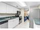 Efficient kitchen featuring white cabinets, stainless appliances, and adjacent living space at 134 Sycamore Ln # F, Oldsmar, FL 34677