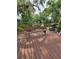 Wooden dock with memorial bench overlooking a serene pond shaded by mature trees and lush vegetation at 1412 Sunset Ln, Lutz, FL 33549