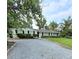 Charming single-story home with a gravel driveway and well-maintained landscaping at 1412 Sunset Ln, Lutz, FL 33549