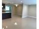 Open-concept living area with glossy tile floors, leading to the kitchen and dining spaces at 1412 Sunset Ln, Lutz, FL 33549