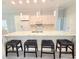 Modern kitchen featuring an oversized island, white cabinetry, and pendant lighting at 1415 Beach Club, Apollo Beach, FL 33572